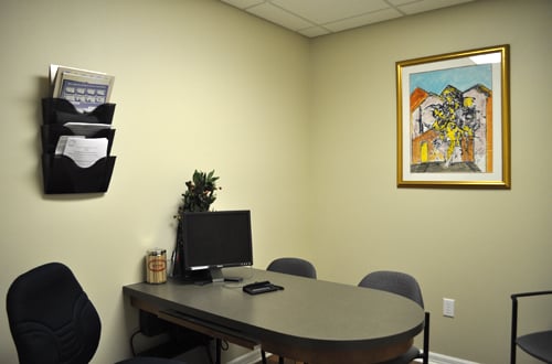 Private consultation office with desk, computer, and framed artwork