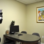 Private consultation office with desk, computer, and framed artwork
