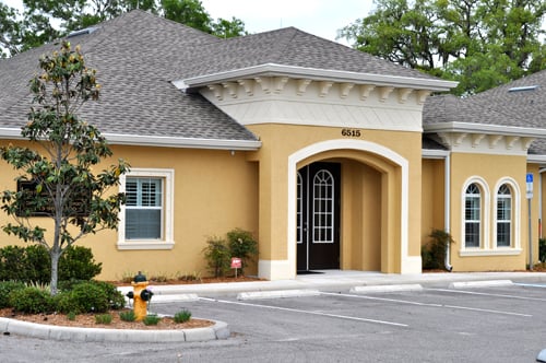 Yellow stucco medical building with Mediterranean architecture and arched entrance