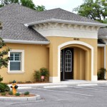 Yellow stucco medical building with Mediterranean architecture and arched entrance