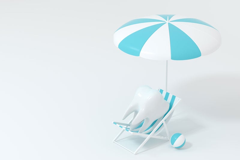 Tooth in a beach chair with an umbrella.