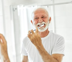 hombre cepillándose los dientes en el baño