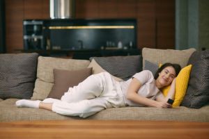 girl recovering on couch from oral surgery procedure 