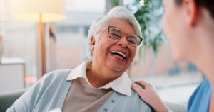 Elderly woman smiling up at caregiver